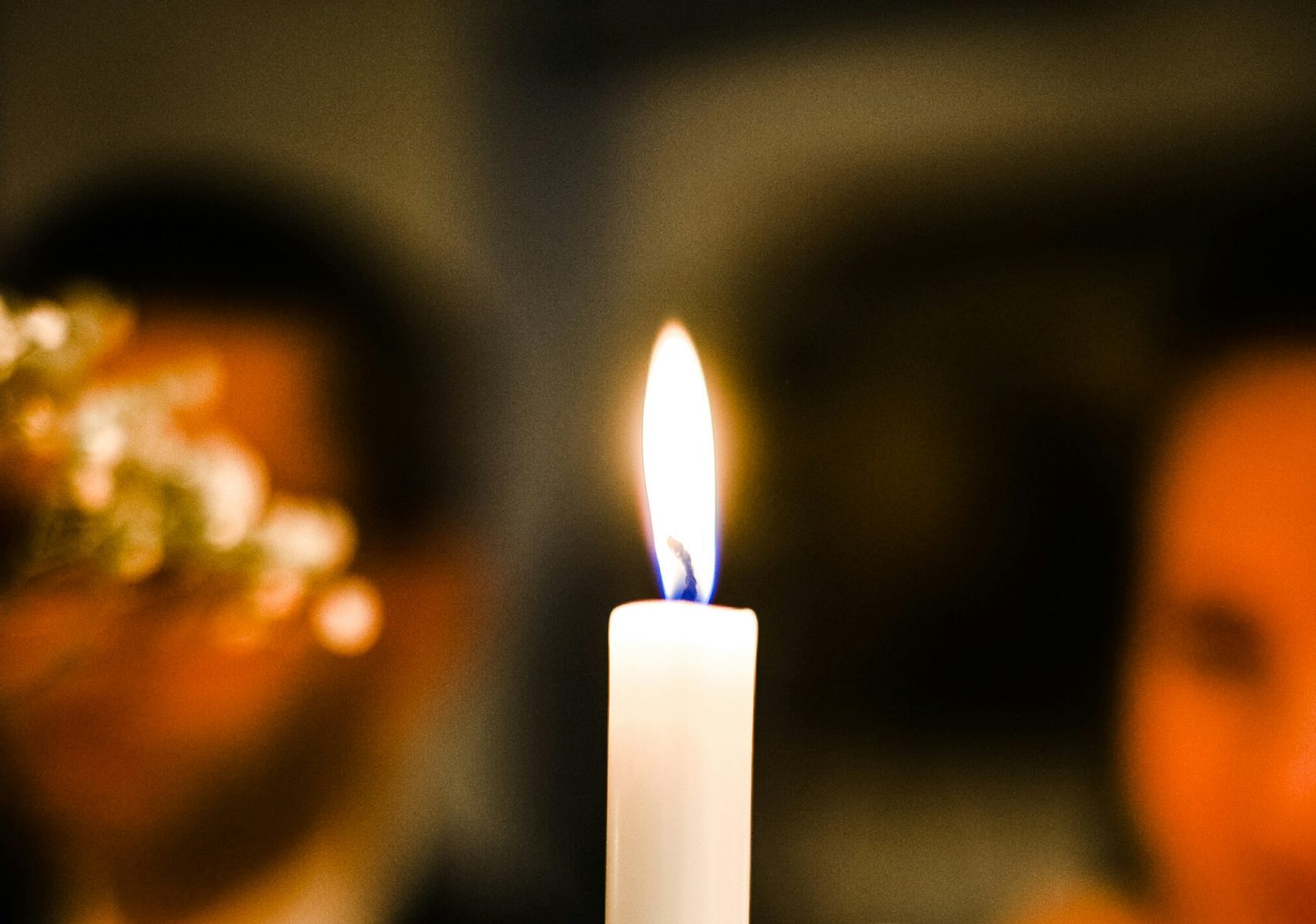 couple sitting behind a lit candle